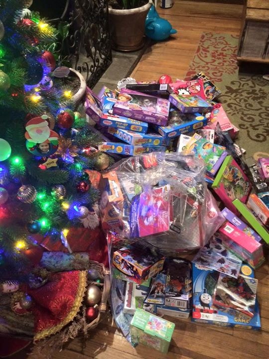 Colorful toys piled under a lit Christmas tree